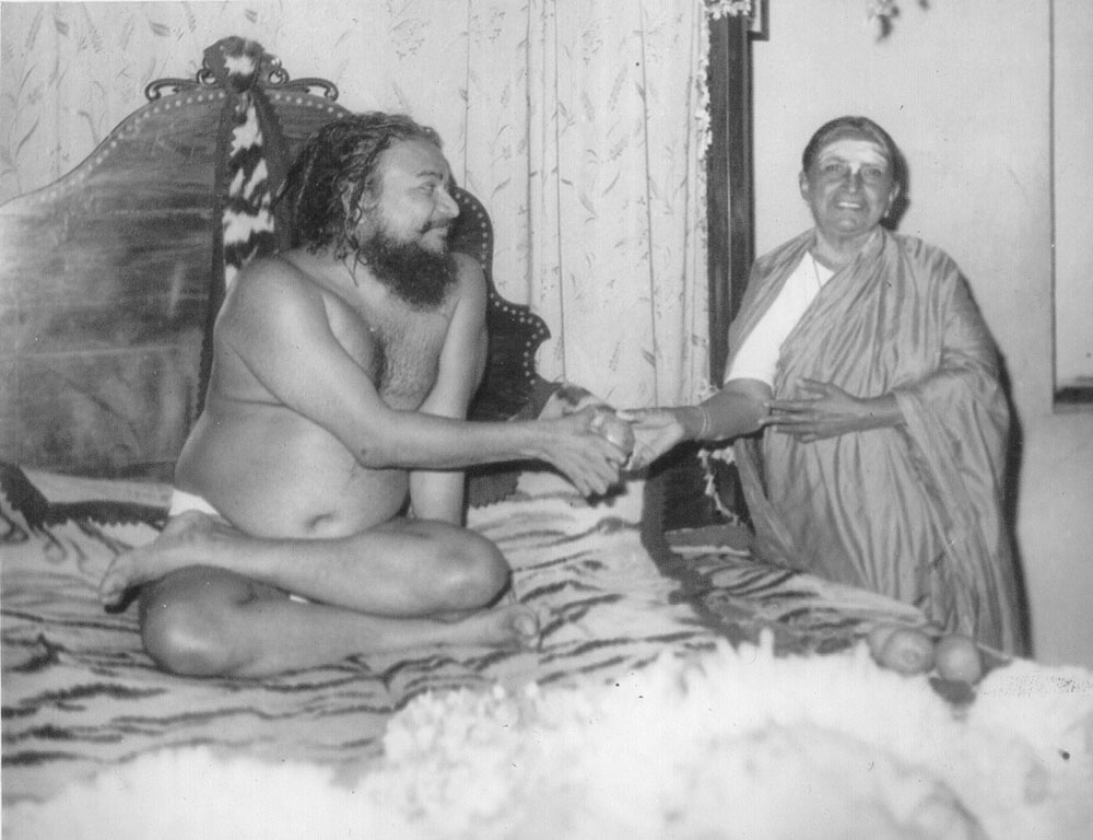 Swamiji giving prasad (blessed food) to His mother, Parvatamma.